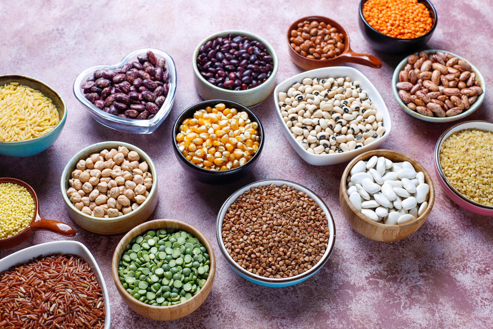 Blog legumes and beans assortment in different bowls on light stone b
